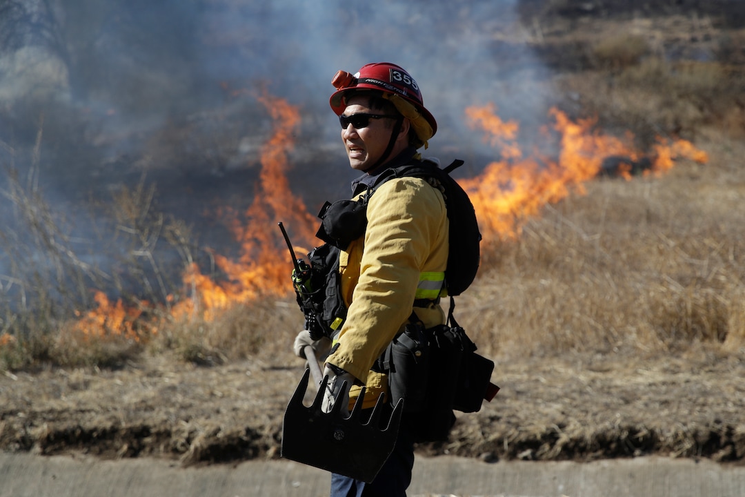 (Marcio Jose Sanchez | AP)  Trinh Nguyen, of the Camarillo Fire Dept, monitors the advance of the Easy Fire Wednesday, Oct. 30, 2019, in Simi Valley, Calif. Driven by powerful Santa Ana winds, the brush fire broke out before dawn between the cities of Simi Valley and Moorpark north of Los Angeles and exploded to more than 1,300 acres (526 hectares), threatening 6,500 homes, Ventura County officials said.