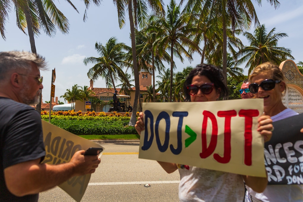 (Saul Martinez | The New York Times) Protestors against former President Donald Trump hold signs near his Mar-a-Lago residence in Palm Beach, Fla. on August 9, 2022. An FBI search of the property, according to multiple people familiar with the investigation, appeared to be focused on material that the former president had brought with him to Mar-a-Lago from the White House.