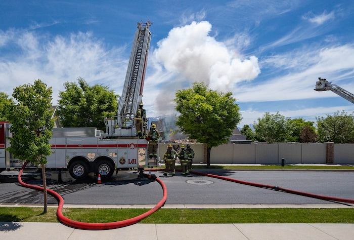 (Francisco Kjolseth | The Salt Lake Tribune) A brief white puff of smoke indicates fire set by firefighters, as South Jordan tears down a house where an owner kept a stockpile of explosives, with fire agencies burning off residual explosives that remained in the basement of the home and could not be safely removed on Tuesday, June 1, 2021.
