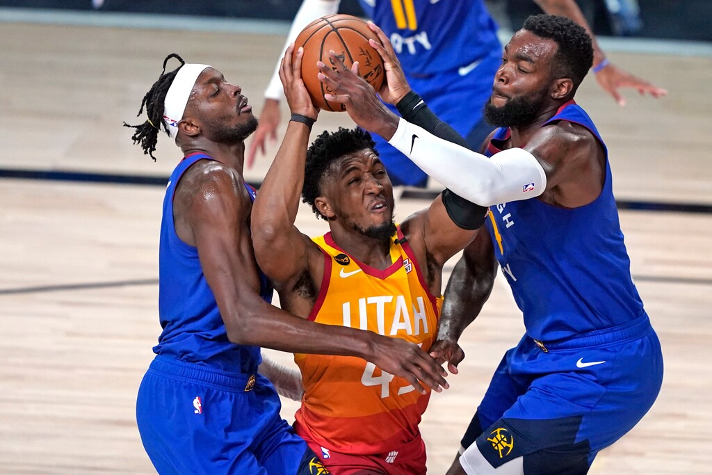 FILE - In this Aug. 30, 2020, file photo, Utah Jazz's Donovan Mitchell, center, goes up to shoot as Denver Nuggets' Jerami Grant, left, and Paul Millsap, right, defend during the second half of an NBA basketball first round playoff game in Lake Buena Vista, Fla. Mitchell agreed Sunday, Nov. 22, 2020, to a five-year, $163 million extension to remain with the Jazz. (AP Photo/Ashley Landis, File)