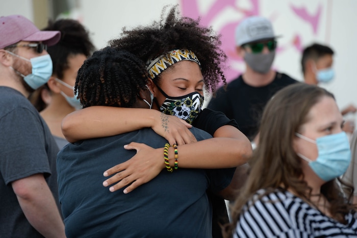 (Francisco Kjolseth  |  The Salt Lake Tribune) Rae Duckworth embraces a friend as she joins a vigil for those killed by police, including her cousin Bobby Duckworth at the murals of those people killed by police near 800 South and 300 West in Salt Lake City on Tuesday, August 11, 2020. Multiple families who’s loved one’s are depicted on the walls joined the vigil as they moved from portrait to portrait to remember them.