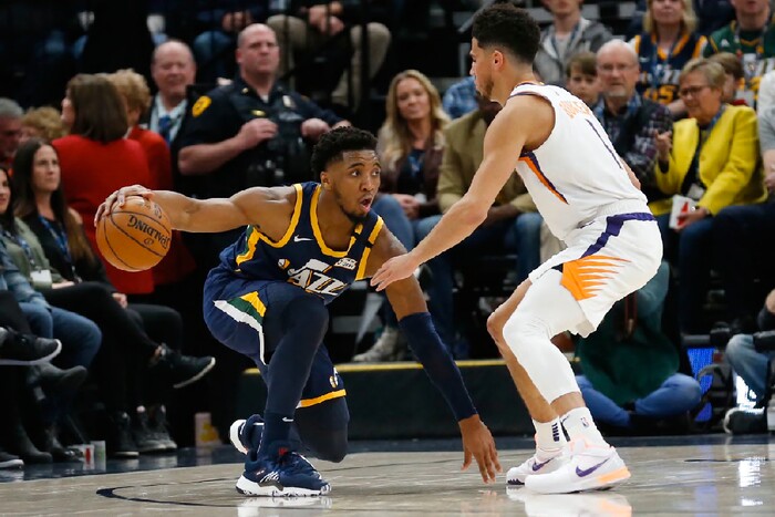 Phoenix Suns guard Devin Booker (1) guards Utah Jazz guard Donovan Mitchell, left, in the second half during an NBA basketball game Monday, Feb. 24, 2020, in Salt Lake City. (AP Photo/Rick Bowmer)