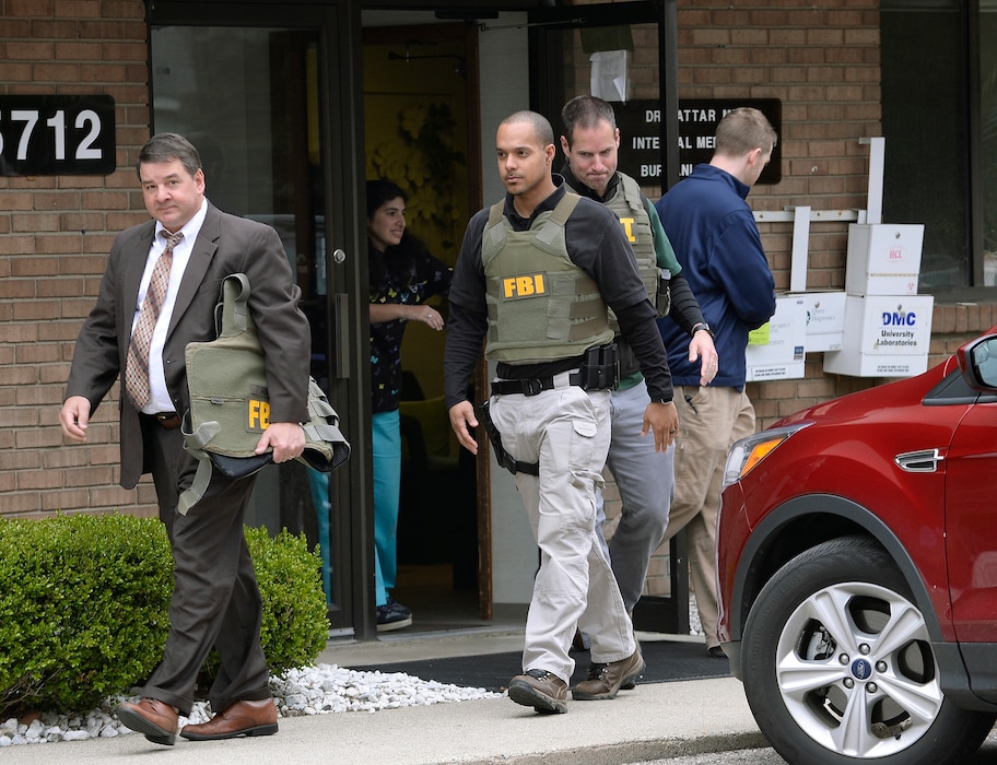 (Clarence Tabb Jr. | Detroit News via AP) In this April 21, 2017 file photo, FBI agents leave the office of Dr. Fakhruddin Attar at the Burhani Clinic in Livonia, Mich., after completing a search for documents. A federal judge dismissed some charges Tuesday, Nov. 20, 2018, against eight people, including two doctors, in the genital mutilation of nine girls at the suburban Detroit clinic, finding it's up to states rather than Congress to regulate the practice.