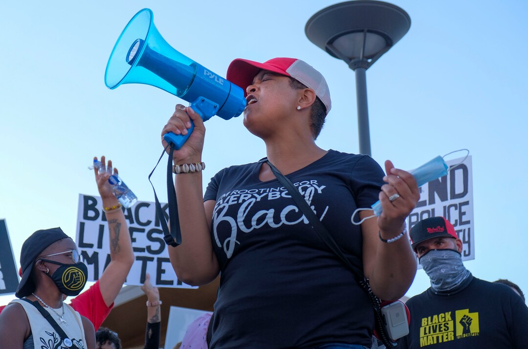 (Leah Hogsten  |  The Salt Lake Tribune) Lex Scott, founder of Black Lives Matter Utah leads the crowd in chants. Five days after after nine protesters were arrested during a peaceful rally in memory of Zane James that turned into a violent clash with Cottonwood Heights officers, demonstrators gathered outside the police station Friday to denounce CHPD's actions and its officers for inciting the violence.