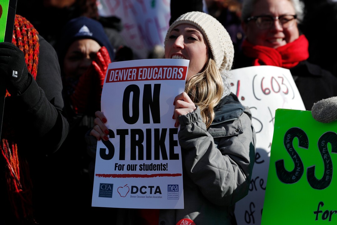 Rebecca Hendricks, a teacher at Emily Griffith High School, waves a sign during a strike rally on the west steps of the State Capitol Monday, Feb. 11, 2019, in Denver. The strike is the first for teachers in Denver since 1994 and centers on base pay. (AP Photo/David Zalubowski)