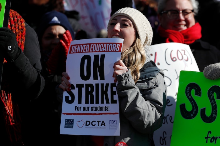 Rebecca Hendricks, a teacher at Emily Griffith High School, waves a sign during a strike rally on the west steps of the State Capitol Monday, Feb. 11, 2019, in Denver. The strike is the first for teachers in Denver since 1994 and centers on base pay. (AP Photo/David Zalubowski)