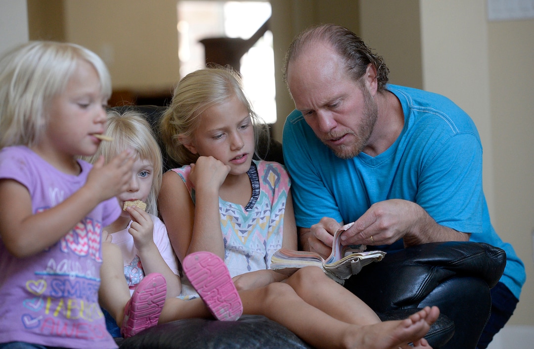 (Al Hartmann  |  The Salt Lake Tribune)
Ken Jensen, a fellowship host in the Remnant movement, picks out a favorite song to sing with his family and friends.