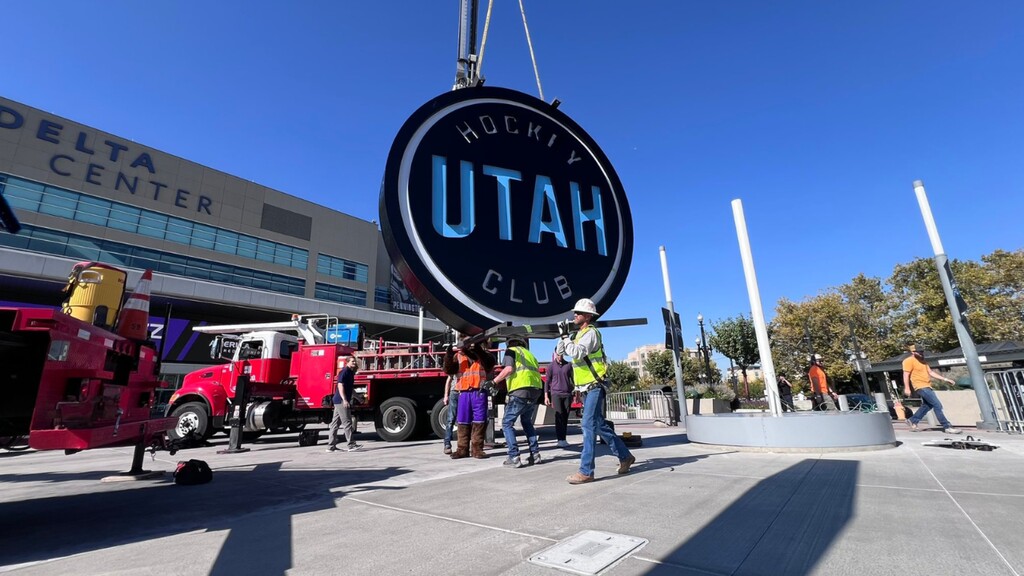 (Fox 13) Crews used a crane to hoist a massive hockey puck adorned with Utah Hockey Club branding to sit alongside the Jazz note that represents the Delta Center's resident NBA team.