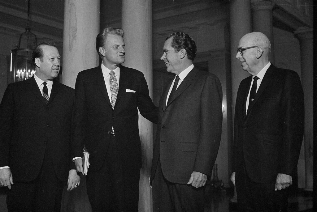 (AP Photo/Henry Burroughs) President Richard Nixon chats with evangelist Billy Graham, Oct. 22, 1969, before a White House breakfast to observe National Day of Prayer.  From left:  Rep. Del Clawson, R-Calif.; Graham; Nixon; and Sen. Wallace F. Bennett, R-Utah.