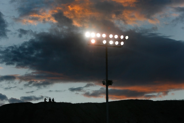 (Scott Sommerdorf   |  The Salt Lake Tribune) Three young Carbon High fans watch from a hillside on the home team's side of he field as Duchesne was crafting a 35-0 win against Carbon High to run their winning streak to 37 games, and setting the Utah state record for consecutive wins, Friday, September 6, 2013. 