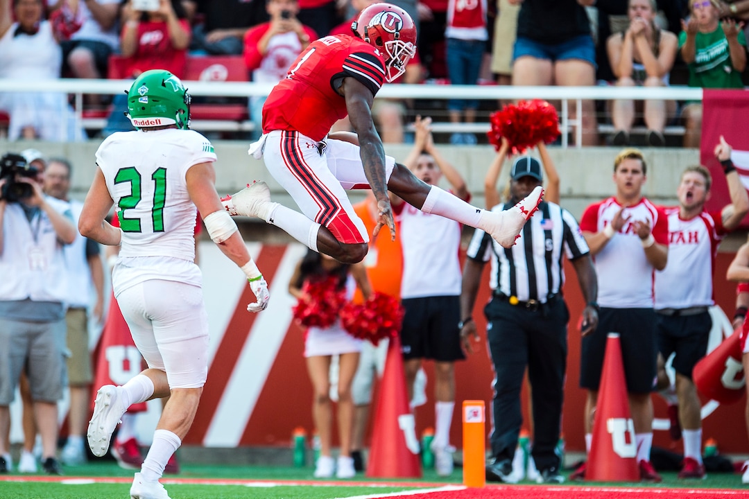 (Chris Detrick  |  The Salt Lake Tribune)  Utah Utes quarterback Tyler Huntley (1) scores a touchdown past North Dakota Fighting Hawks defensive back Tanner Palmborg (21) during the game at Rice-Eccles Stadium Thursday, August 31, 2017. Utah Utes are leading North Dakota Fighting Hawks 17-9 at halftime. 
