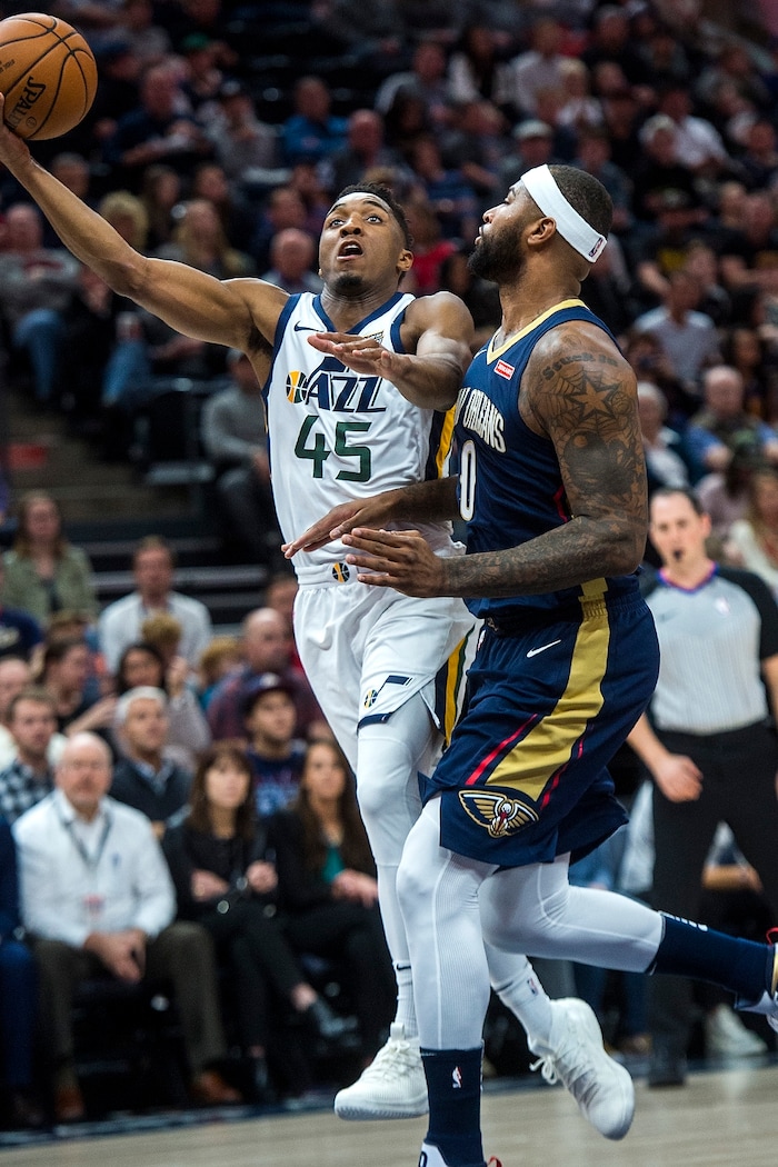 (Chris Detrick  |  The Salt Lake Tribune)  Utah Jazz guard Donovan Mitchell (45) shoots past New Orleans Pelicans center DeMarcus Cousins (0) during the game at Vivint Smart Home Arena Friday, December 1, 2017.  
