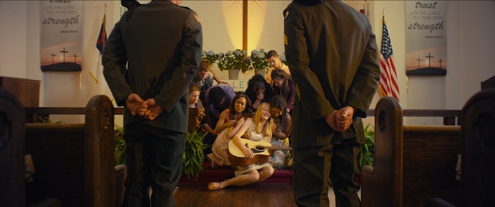 (photo courtesy Freestyle Releasing) Amber (Lindsay Pulsipher, center) gets tragic news about her soldier husband during church choir practice, in the drama "God Bless the Broken Road."