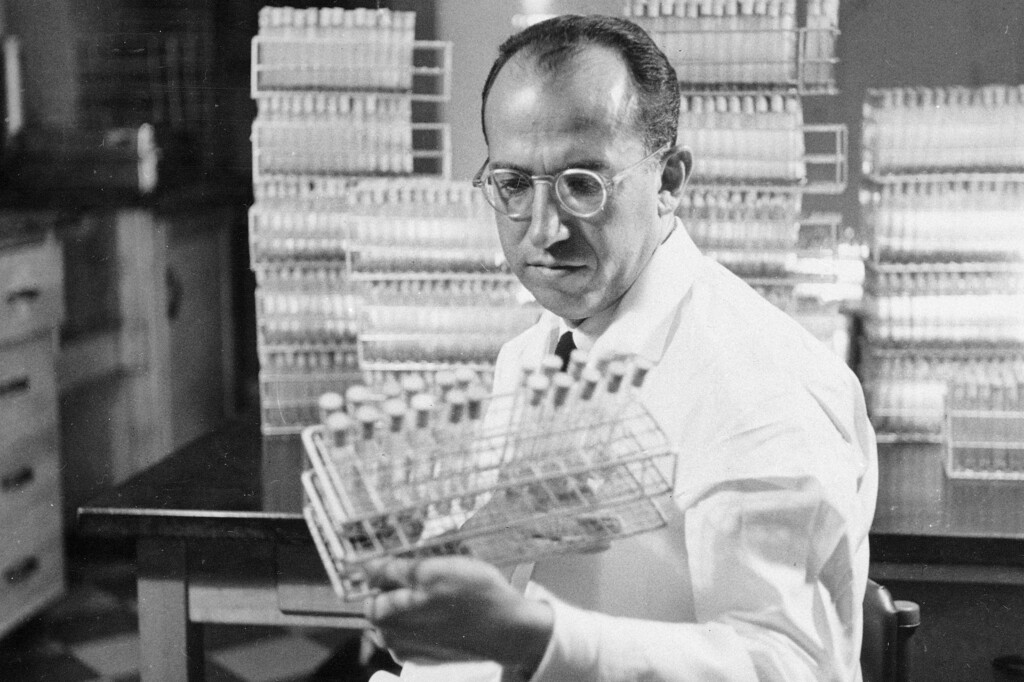 In this Oct. 7, 1954, photo, Dr. Jonas Salk, developer of the polio vaccine, holds a rack of test tubes in his lab in Pittsburgh, Pennsylvania.