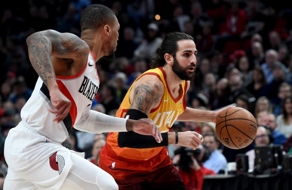 Utah Jazz guard Ricky Rubio, right, drives to the basket on Portland Trail Blazers guard Damian Lillard during the first half of an NBA basketball game in Portland, Ore., Wednesday, Jan. 30, 2019. (AP Photo/Steve Dykes)