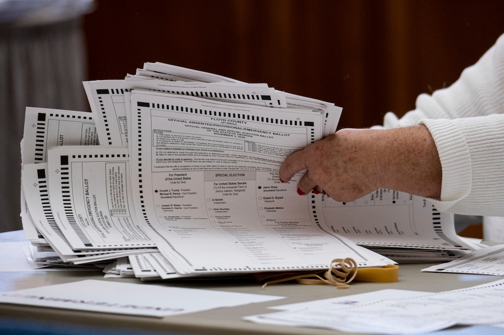 Officials sort ballots during an audit at the Floyd County administration building in Rome, Ga. on Friday morning, Nov. 13, 2020. Election officials in Georgia’s 159 counties undertook a hand tally of the presidential race that stemmed from an audit required by state law.  (AP Photo/Ben Gray)