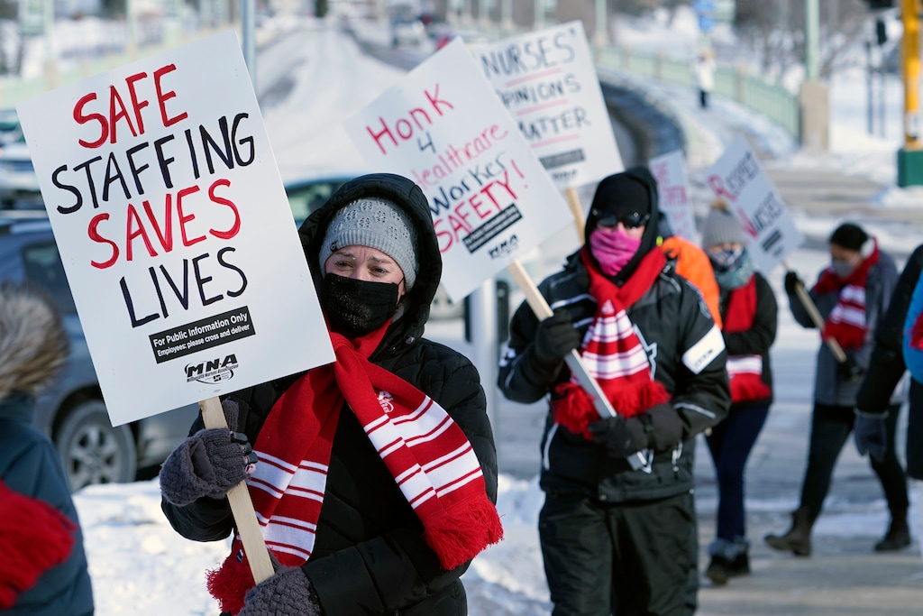 (Jim Mone | AP) Nurses picket Friday, Feb. 12, 2021 in Faribault, Minn., during a healthcare worker protest of a shortage on protective masks. One year into the COVID-19 pandemic, the U.S. finds itself with many millions of N95 masks pouring out of American factories and heading into storage. Yet there still aren’t nearly enough in ICU rooms and hospitals.