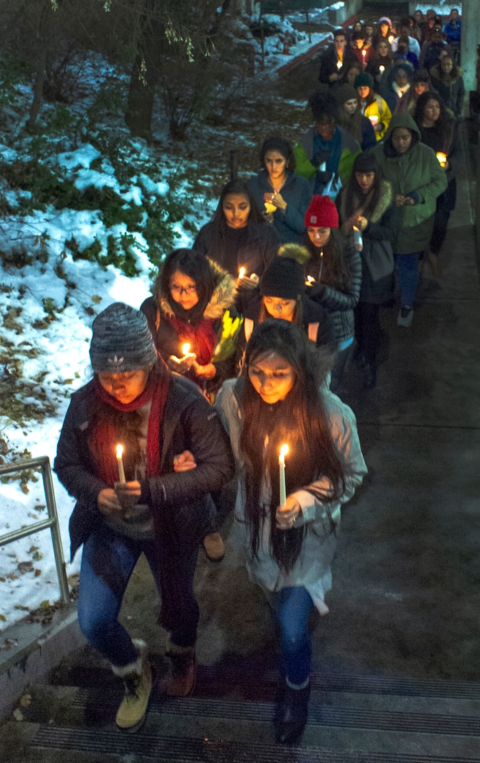 (Rick Egan  |  The Salt Lake Tribune)       Erin Tapahe and Meeya Apelu, lead a procession up the hill, to the top entrance of the Tanner building, during a candlelight vigil on BYU campus, for the student who died by suicide this week, Friday, Dec. 7, 2018.
  
