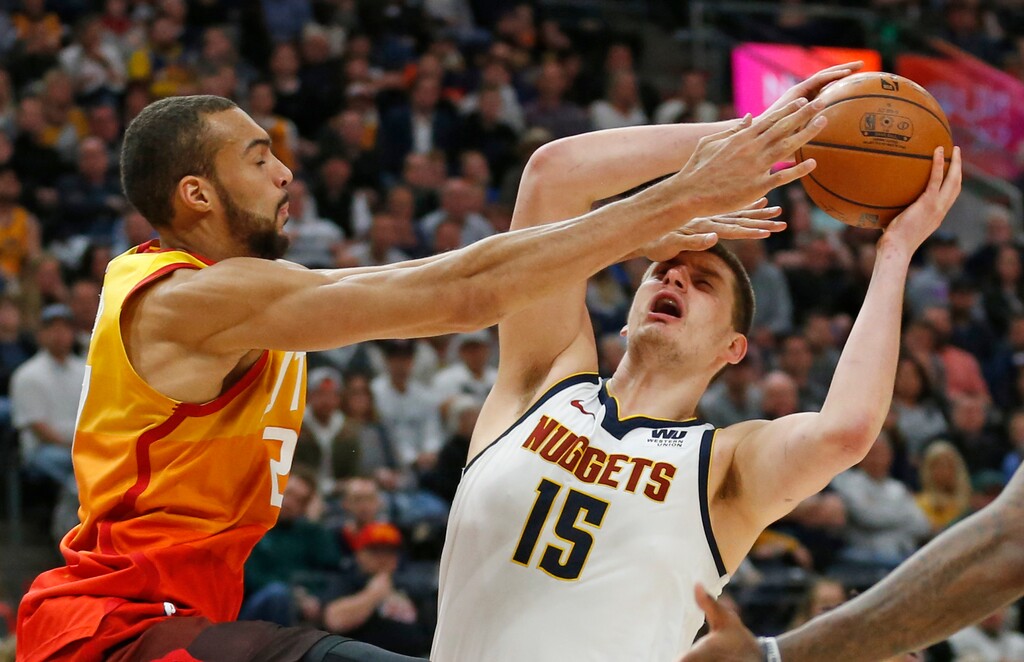 Utah Jazz center Rudy Gobert, left, defends against Denver Nuggets center Nikola Jokic (15) in the first half during an NBA basketball game Tuesday, April 9, 2019, in Salt Lake City. (AP Photo/Rick Bowmer)