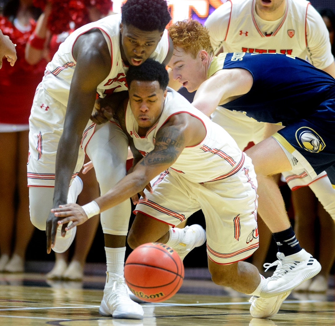 (Steve Griffin  |  The Salt Lake Tribune)  Utah Utes forward Donnie Tillman (3) and Utah Utes guard Justin Bibbins (1) crash into each other during the Utah versus UC Davis men's NIT basketball game at the Huntsman Center in Salt Lake City Wednesday March 14, 2018.