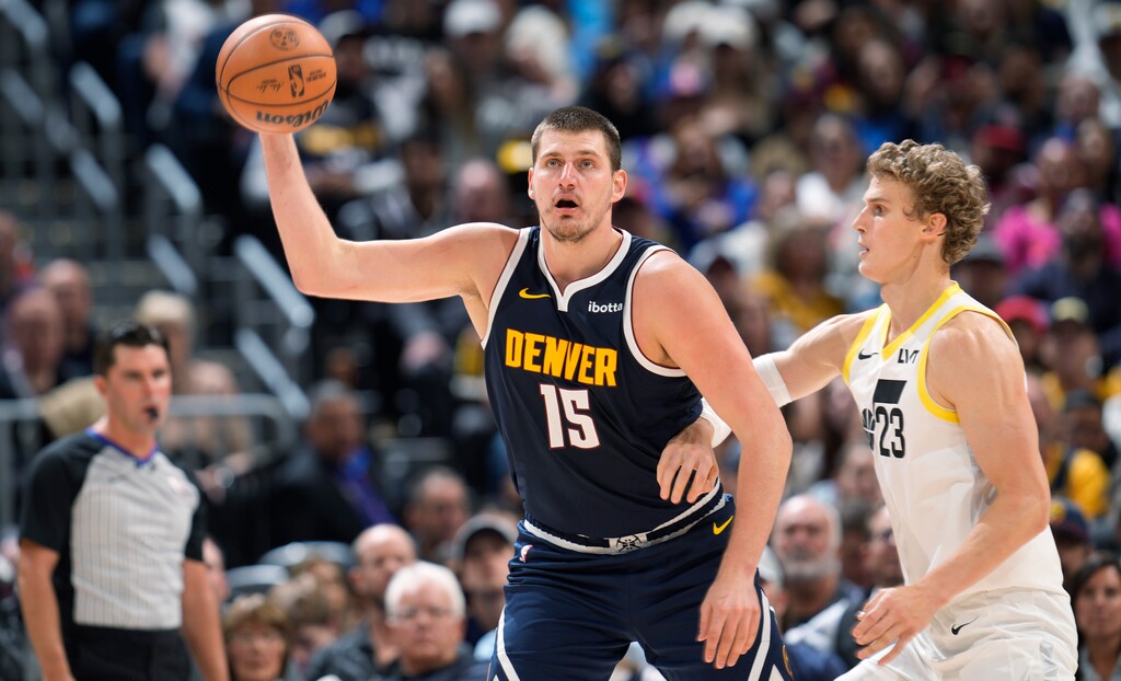 Denver Nuggets center Nikola Jokic, left, fields a pass as Utah Jazz forward Lauri Markkanen defends in the second half of an NBA basketball game, Monday, Oct. 30, 2023, in Denver. (AP Photo/David Zalubowski)