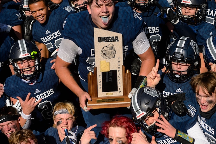 (Trent Nelson  |  The Salt Lake Tribune) Corner Canyon's Jackson Light holds the trophy while celebrating with teammates after the 6A state football championship game against Lone Peak at Cedar Valley High School in Eagle Mountain on Friday, Nov. 20, 2020.