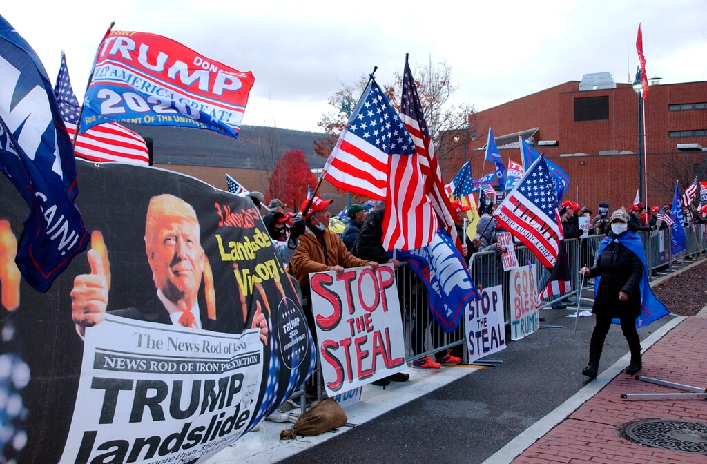 Approximately 100 Trump supporters some with flags and signs stood across West Third Street from the Federal Building in Williamsport, Pa., for hours Tuesday, Nov. 17, 2020, chanting such things as ‘Four More Years,’ ‘Black Lives Matter,’ ‘We Want Trump’ and ‘Dead People Can’t Vote.’ Attorneys for the Trump campaign organization inside the Federal Building were arguing why the state and seven county election boards were arguing should not certify the results of the general election because voters across the state were not treated the same. (John Beauge/The Patriot-News via AP)