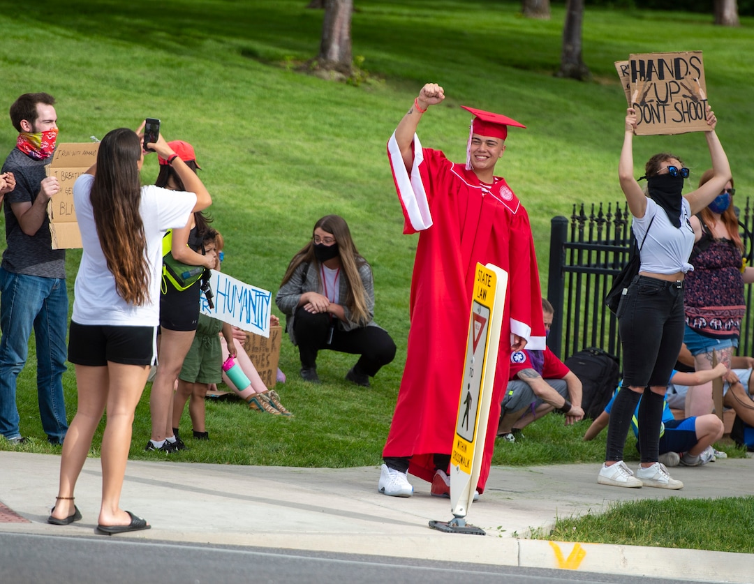 (Rick Egan  |  The Salt Lake Tribune) A young man in a cap and gown poses for a photo during a protest against police brutality in Salt Lake City on June 2, 2020.