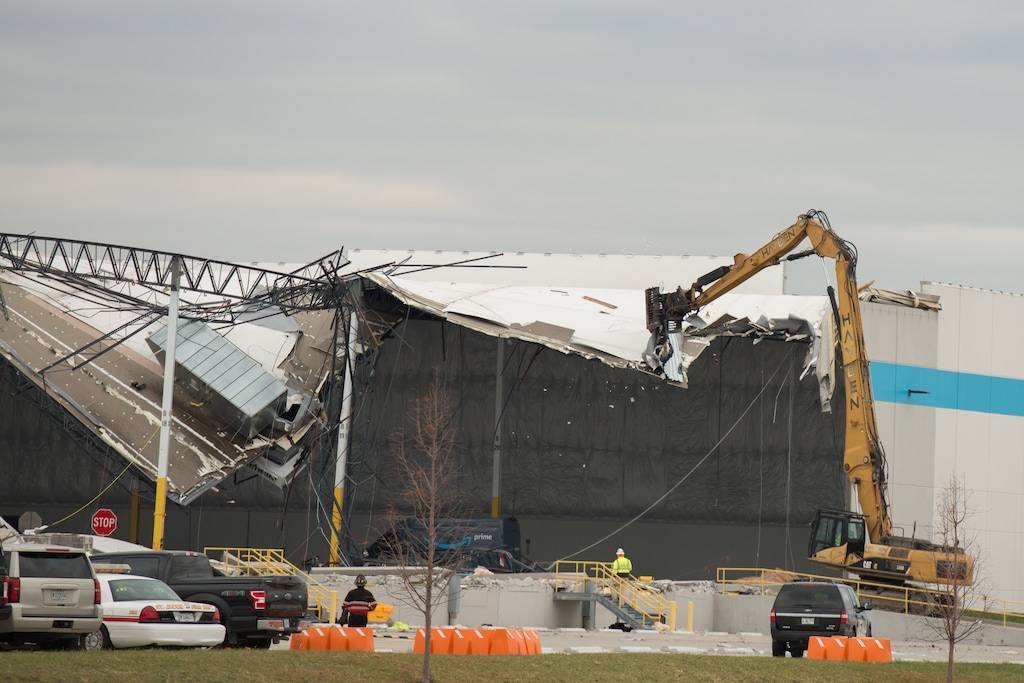(Neeta Satam| The New York Times)
An excavator clears building debris from the Amazon warehouse hit by a tornado storm in Edwardsville, Ill., Dec. 11, 2021. The police in Edwardsville said there were at least two "confirmed fatalities" here after a direct hit from a tornado caused a major portion of the building to collapse on Friday night.