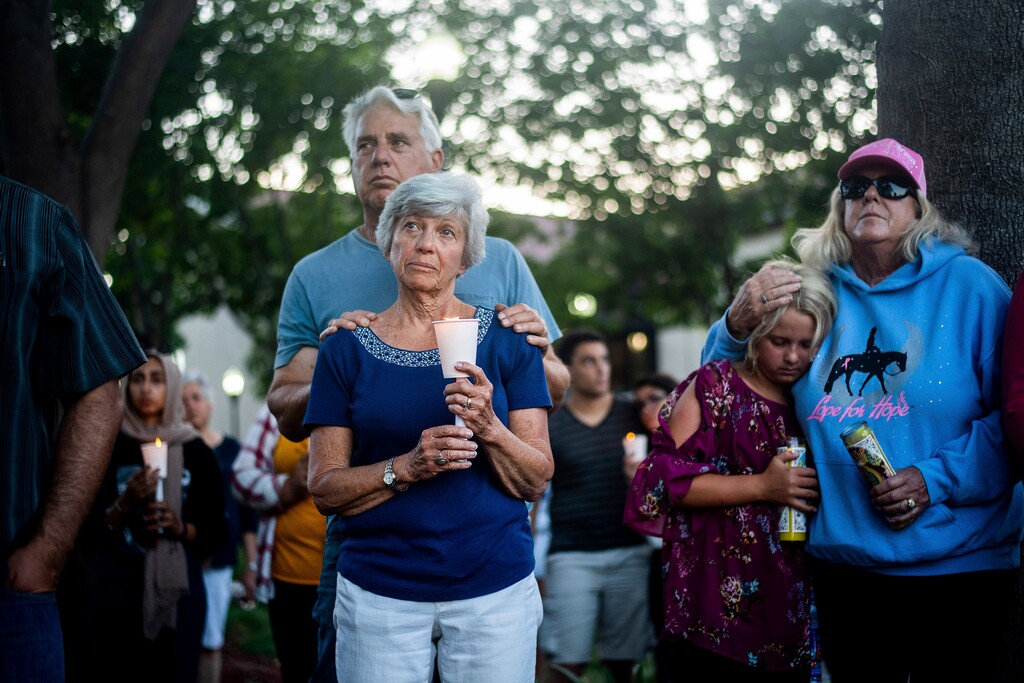 (Noah Berger | AP Photo) Susan Meyers and husband Michael Oshan listen to a hymn during a vigil for victims of a Sunday evening shooting that left three people dead at the Gilroy Garlic Festival, Monday, July 29, 2019, in Gilroy, Calif.