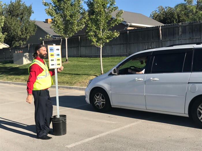 (Benjamin Wood | The Salt Lake Tribune)   Faculty members with American Preparatory Academy in Draper helped direct traffic as families arrived Monday for the first day of the 2017-2018 school year.