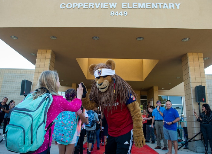 (Rick Egan | The Salt Lake Tribune) Real Salt Lake mascot Leo the Lion gives high-fives to students as they walk the red carpet on the first day of school at Copperview Elementary School in Midvale, Monday, Aug. 19, 2019.
