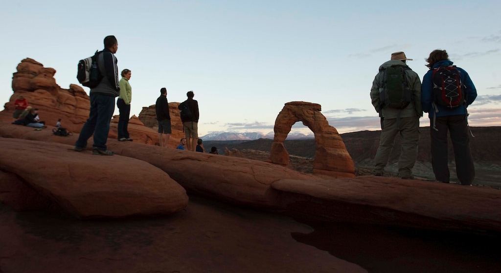 (Leah Hogsten | The Salt Lake Tribune) Visitors mingled around Delicate Arch to watch the sunset in Arches National Park on October 11, 2014.