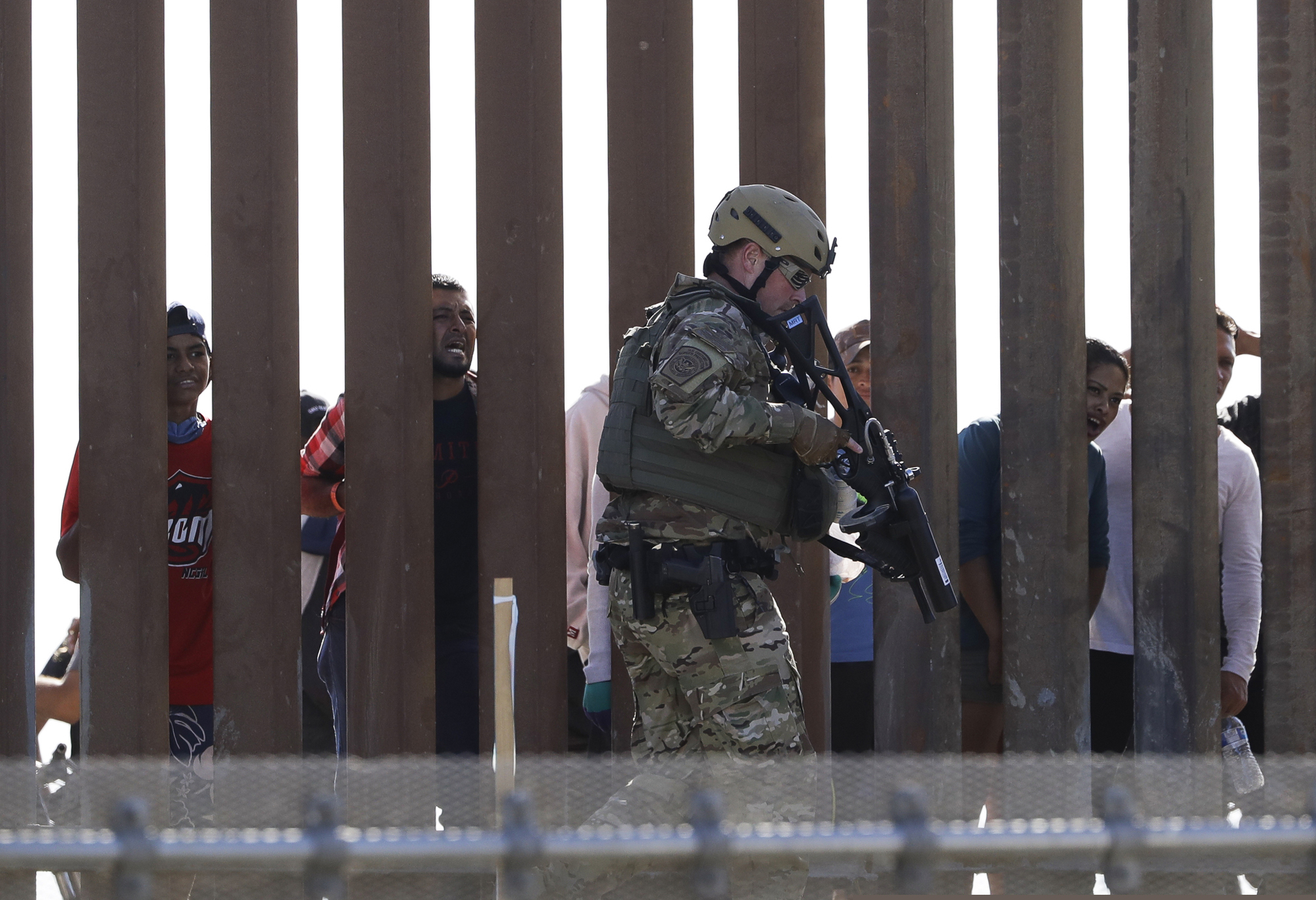 (Greg Bull | The Associated Press) U.S. Customs and Border Protection officers walks along a wall at the border between Mexico and the United States, as seen from San Diego on Sunday, Nov. 25, 2018. Migrants approaching the U.S. border from Mexico were enveloped with tear gas Sunday after a few tried to breach a fence separating the two countries. The Border Patrol office in San Diego said via Twitter that pedestrian crossings have been suspended at the San Ysidro port of entry at both the East and West facilities. All northbound and southbound traffic was halted.