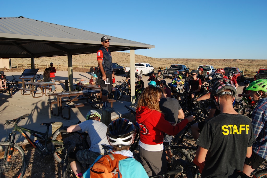 (Brian Maffly | The Salt Lake Tribune) Cycling coach Jesse Atwood, standing on the table, addresses members of the Uintah High School mountain bike team before a practice ride Oct. 7, 2019, at the McCoy Flats trail complex outside Vernal. Like many of the other trails under development in Uintah County, the McCoy Flats loops cross state trust lands, which are embedded among public lands in checkerboard sections. Trust lands officials are concerned Utah's expansion of trail-oriented recreation could inhibit mineral development on these lands, which are to be managed to raise money for public education.