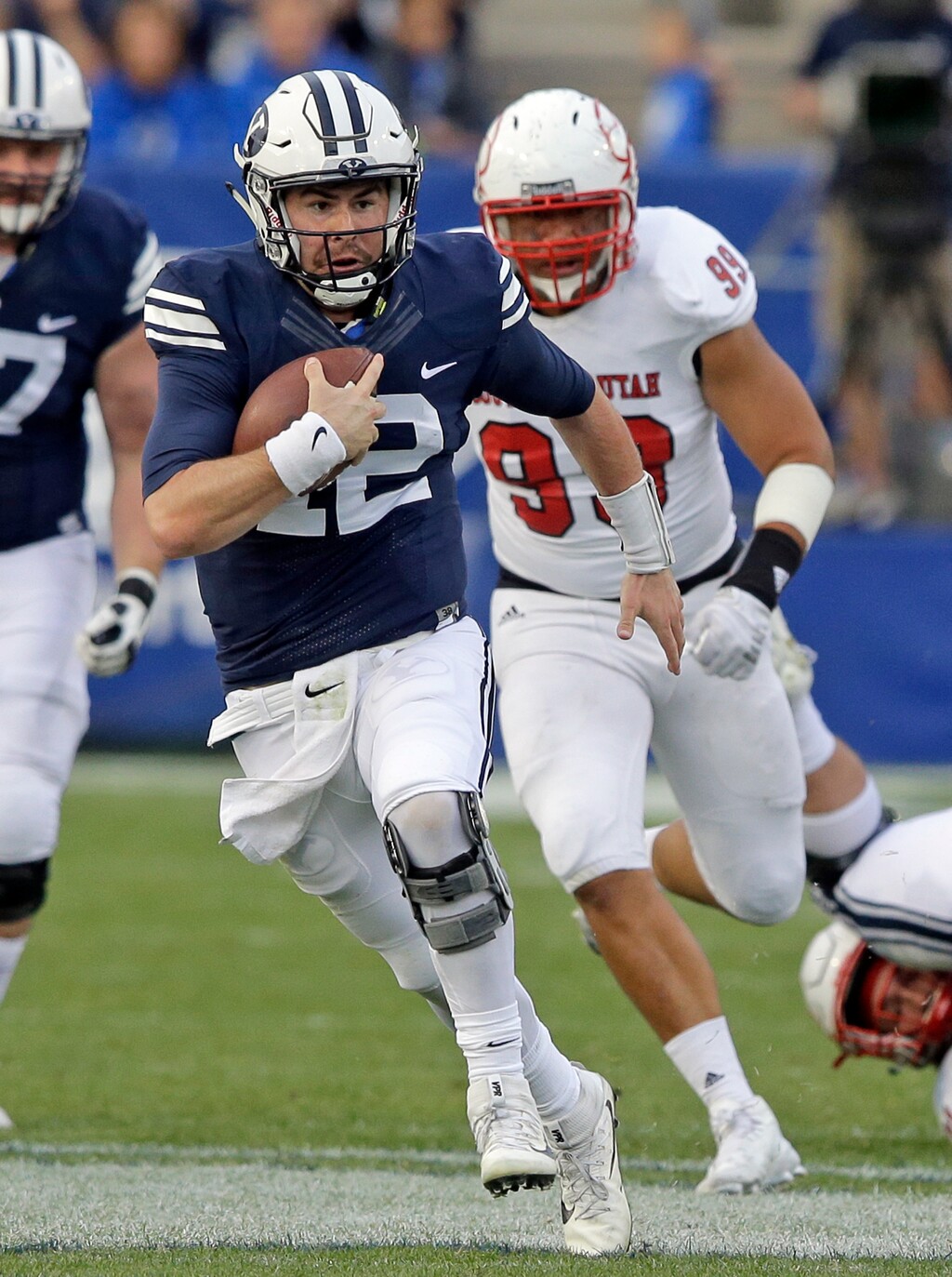 BYU quarterback Tanner Mangum, left, carries the ball as he is pursued by Southern Utah defensive lineman Sione Fukofuka (99) in the second half during an NCAA college football game, Saturday, Nov. 12, 2016, in Provo, Utah. BYU won 37-7. (AP Photo/Rick Bowmer)