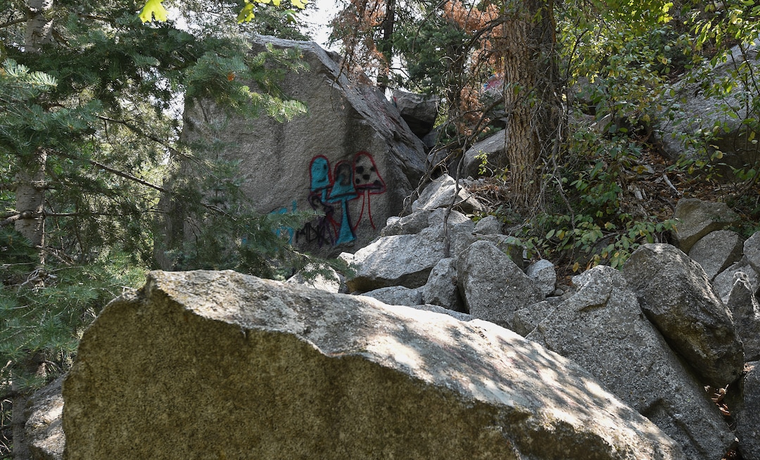 (Francisco Kjolseth  |  The Salt Lake Tribune)  Graffiti has proliferated in lower Little Cottonwood Canyon, where vandals, often wielding cans of fluorescent-colored spray paint, have covered granite faces, trees and structures. The vandalism is particularly apparent along the Temple Quarry Trail and the creek at the Moon Rock swimming hole and former pavilion site. Volunteers using donated equipment and solvents spend thousands of hours removing the paint from the rocks only to see graffiti return to the same faces or on rock nearby.