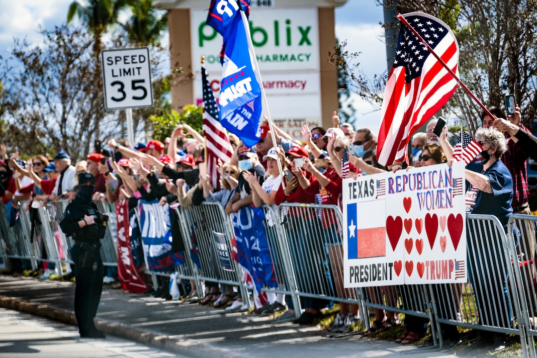 Supporters of outgoing President Donald Trump line the street as his motorcade is driven to his Mar-a-Lago resort in Palm Beach, Fla., on Inauguration Day, Wednesday, Jan. 20, 2021. Defeated and twice impeached, the 45th president used his farewell remarks before a sparse crowd to brag about his record and wish luck to the incoming administration. (Pete Marovich/The New York Times)