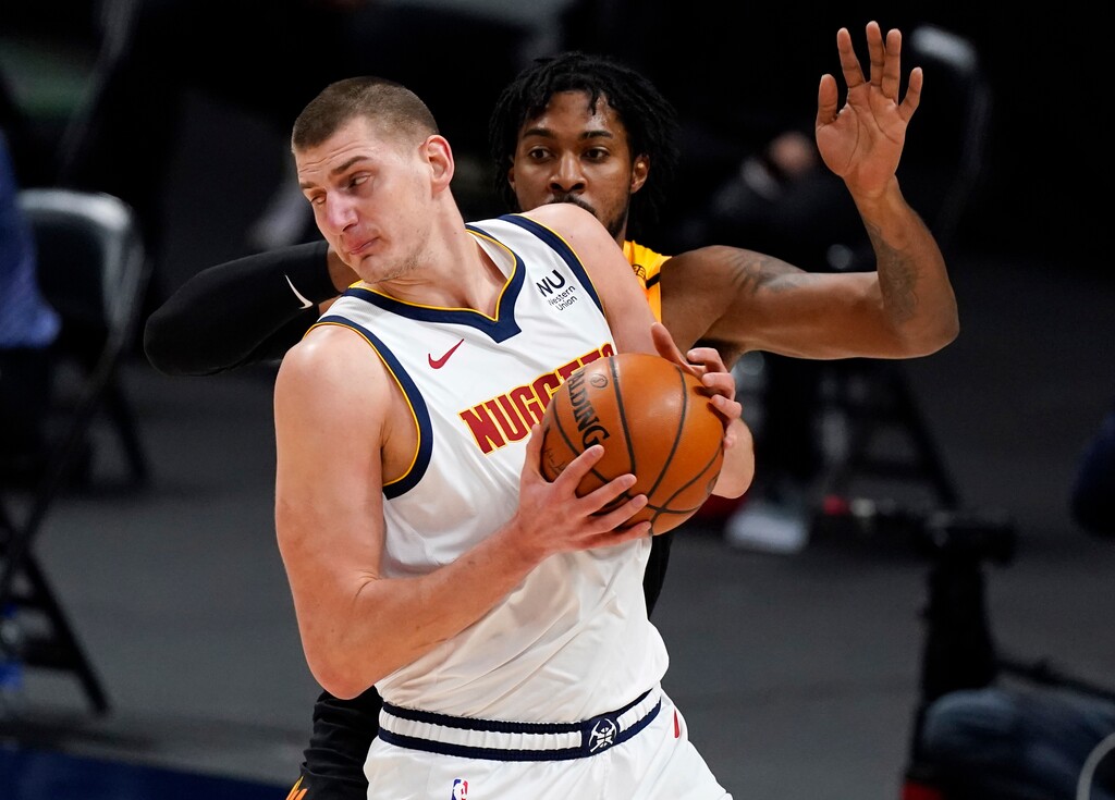 Denver Nuggets center Nikola Jokic, front, works the ball inside as Utah Jazz center Derrick Favors defends in the first half of an NBA basketball game Sunday, Jan. 31, 2021, in Denver. (AP Photo/David Zalubowski)