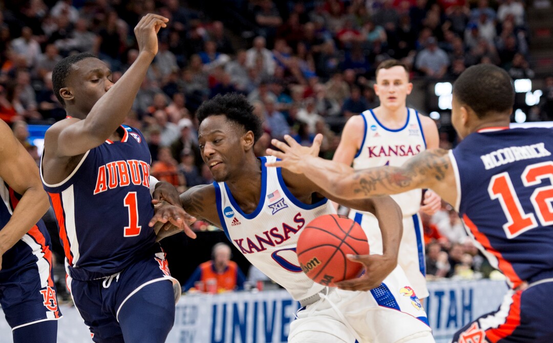 (Leah Hogsten  | The Salt Lake Tribune)  Kansas Jayhawks guard Marcus Garrett (0) tries to drive past Auburn Tigers guard Jared Harper (1) and Auburn Tigers guard J'Von McCormick (12) as Auburn faces Kansas in the second round of the NCAA tournament in Salt Lake City on Saturday, March 23, 2019.