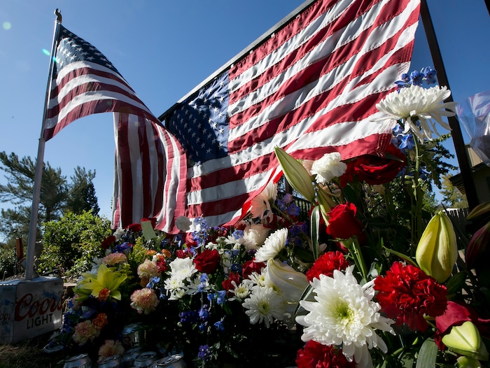 Flags and flowers make up a memorial on the backyard fence of Las Vegas shooting victim Kurt Von Tillow, Wednesday, Oct. 4, 2017, in Cameron Park, Calif. Von Tillow, 55, was at Sunday's concert with his wife, daughter, son-in-law and other family members when the shooting started, KCRA reported. (AP Photo/Rich Pedroncelli)