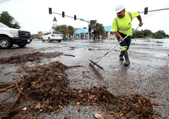(Jennifer Reynolds | The Galveston County Daily News via AP) German Martinez, with Galveston's Public Works department, clears debris from the intersection of 33rd Street and Broadway on Saturday, Aug. 26, 2017, as high waters from Hurricane Harvey begin to recede.