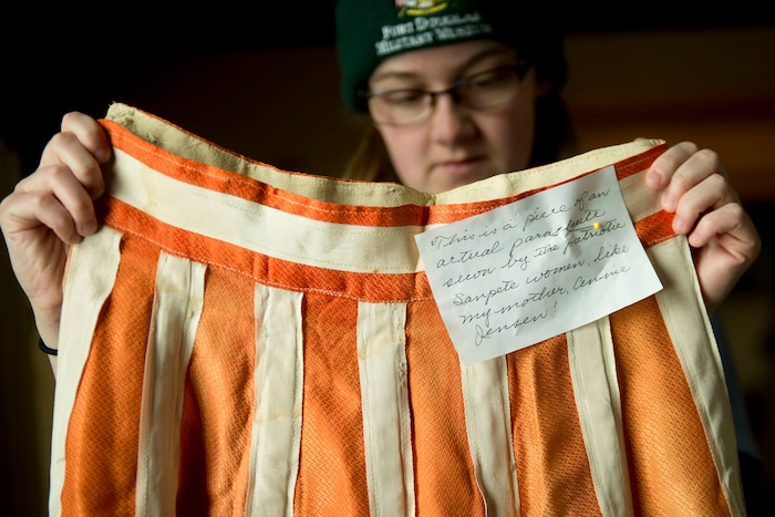 (Jeremy Harmon |The Salt Lake Tribune) Rachel Heaton, an employee at the Fort Douglas Military History Museum, shows a skirt made out of parachute silk. Items like it were made during and after the war in part because parachute factories in Manti led to Utahns having access to silk and nylon used to make the chutes.