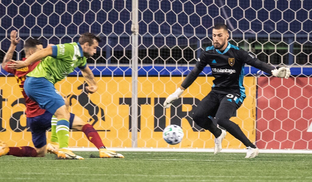The cross to Seattle Sounders' Jordan Morris leads to the first goal of the match, as Morris beats Real Salt Lake goalkeeper Andrew Putna on the shot during the first half of an MLS soccer match Wednesday, Oct. 7, 2020, in Seattle. (Dean Rutz/The Seattle Times via AP)