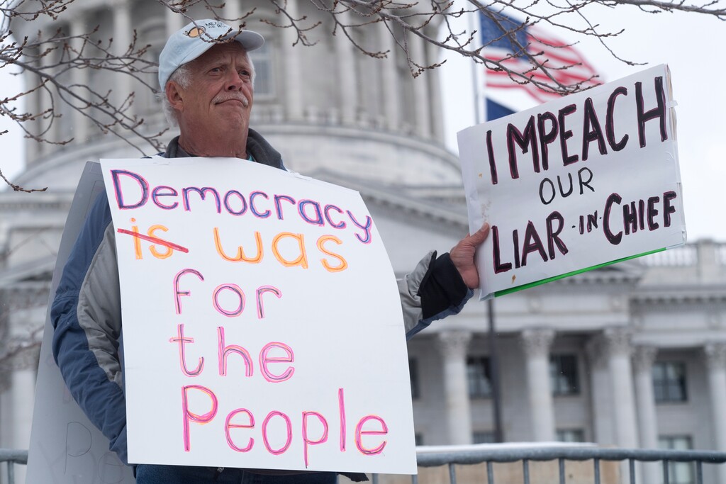 (Rick Egan  |  The Salt Lake Tribune)  Glenn Hayes, Grand Junction, Colorado, holds a sign as protesters gather for President Trump's visit to Utah, in front of the Utah State Capitol Building, as he is expected to shrink the Bears Ears and Grand Staircase monuments, iMonday, December 4, 2017.