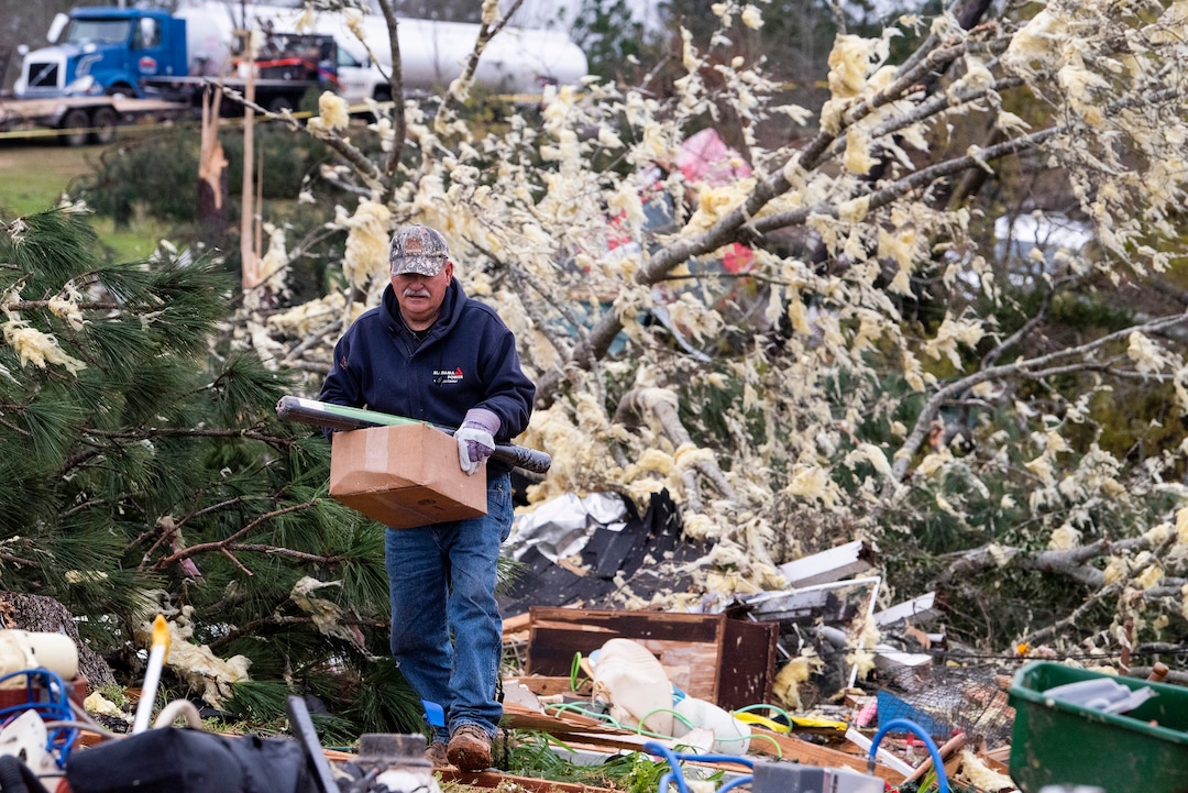 A man salvages belongings near Beauregard, Ala., on Monday March 4, 2019. Friends in eastern Alabama are helping tornado survivors retrieve the scattered pieces of their lives after devastating winds destroyed their homes and killed at least 23 people. (Mickey Welsh/Montgomery Advertiser via AP)