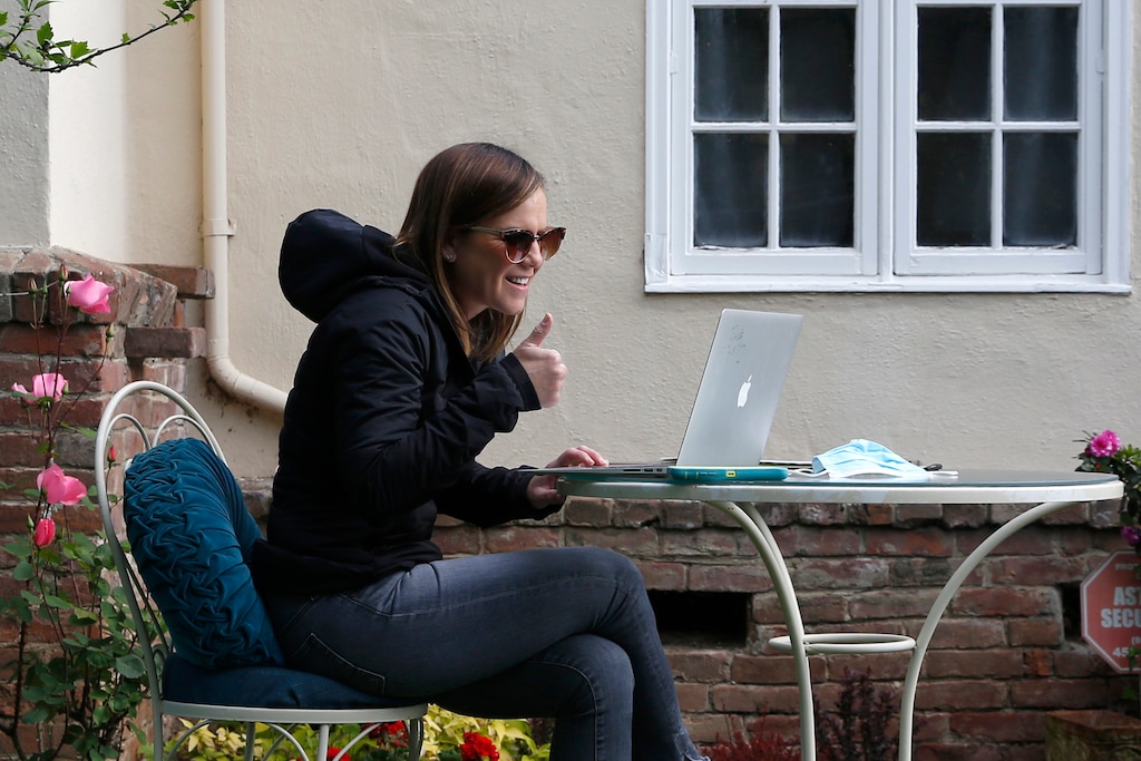 (Rich Pedroncelli | AP file photo) Kelly Dighero, a 3rd grade teacher at Phoebe Hearst Elementary School, gives a thumbs-up during her first online meeting with students and parents on the front lawn of her home in Sacramento, Calif. Monday was the first day of the Sacramento Unified School District's "Distance Learning" program.