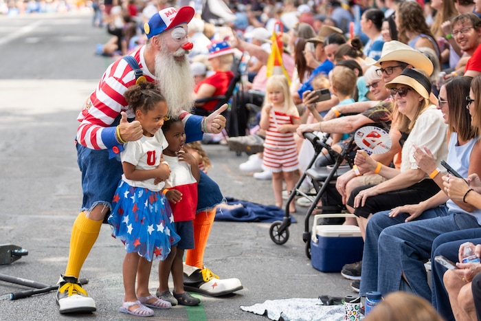 (Rick Egan | The Salt Lake Tribune) Mr. Zach the clown poses for a photo with Maddy and Kingston at the Days of '47 Parade in Salt Lake City on Thursday, July 24, 2025.