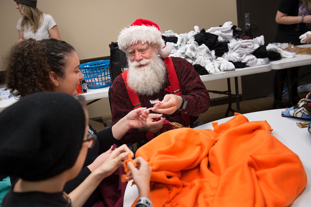 (Scott Sommerdorf   |  The Salt Lake Tribune)   Fred Lane offers a fellow volunteer a candy cane during a break tying fleece tied blankets as Lady Gaga's Born This Way Foundation hosted an event at the Maverick Center to assemble care packages and write ÒKindness LettersÓ expressing support, hope, and love for LGBT+ youth experiencing homelessness in the area, Thursday, December 14, 2017.   