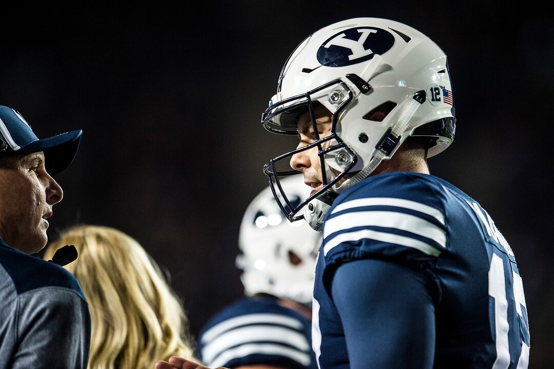 (Chris Detrick  |  The Salt Lake Tribune)  Brigham Young Cougars quarterback Tanner Mangum (12) talks with Offensive Coordinator and Quarterbacks Coach Ty Detmer during the game LaVell Edwards Stadium Friday, October 6, 2017. 
